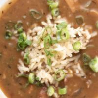 Piri Piri Chicken & Andouille Sausage Gumbo · Topped with white rice and parsley flakes.