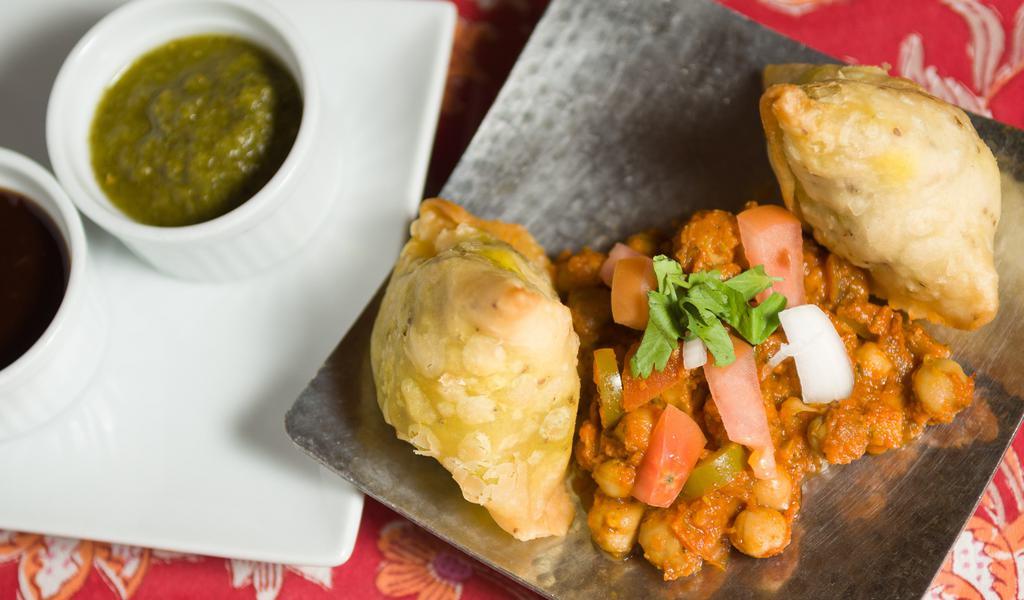 Vegetable Samosa · Two crispy pastries stuffed with potatoes and peas, served with channa masala.
