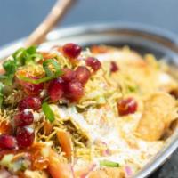 Papdi Chaat · Crispy flour chips topped with yogurt, chickpeas, potatoes, and chutneys.