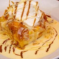 French White Chocolate Bread Pudding · Fresh croissants baked with Godiva white chocolate liqueur and golden raisins. Topped with w...