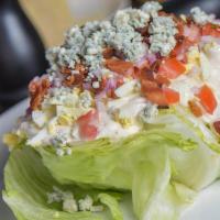 Wedge Salad · Iceberg lettuce, tomatoes, bacon, hard-boiled egg, onions, bleu cheese crumbles & homemade b...