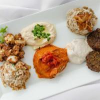 Arabian Breeze Mezza · Hummus, muhamara, caramelized onions mixed with tahini, majadra, fried cauliflower, and fala...