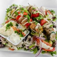 Zaatar Salmon Kabob Salad · Atlantic salmon marinated in zaatar, olive oil, garlic, and lemon. Served with two skewers o...