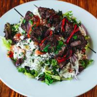 Lamb Kabob Salad · Lamb marinated in olive oil, garlic, mint, and lemon. Served with two skewers over mixed gre...