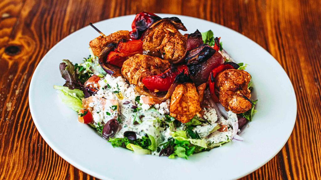 Chicken Breast Kabob Salad · Chicken breast marinated in olive oil, garlic, yogurt, paprika, and lemon. Served with two skewers over mixed greens, cucumbers, tomatoes, onions, feta cheese, and kalamata olives, then topped with our house dressing. GF