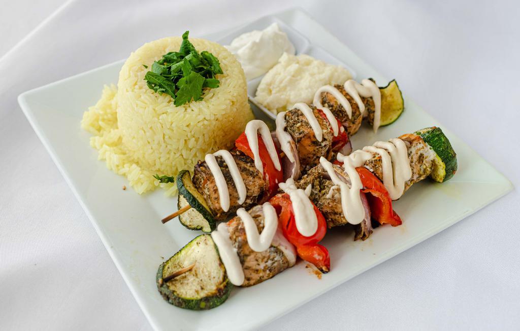 Zaatar Salmon Kabob Plate · Atlantic salmon marinated in zaatar, olive oil, garlic, and lemon. Kabob plates are served with two skewers over saffron jasmine rice. Served with tahini and toum. GF