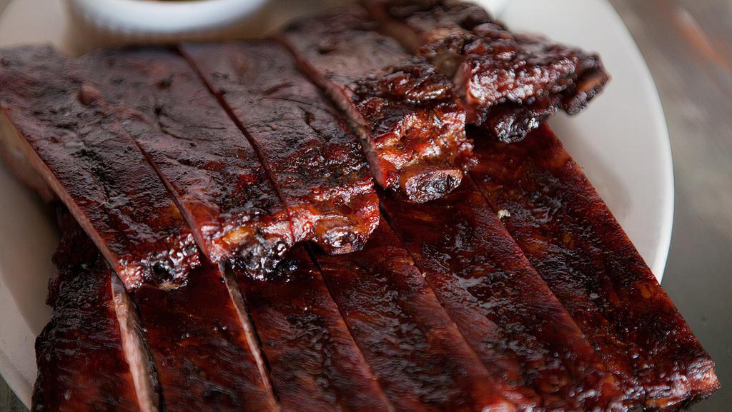 Our Signature Style Ribs · Our pork spare ribs are slow smoked to create a perfectly balanced smoky taste. Served with choice of two sides and a corn muffin.