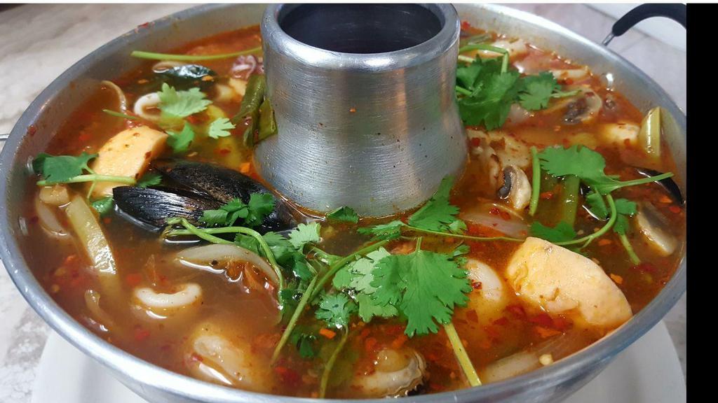 Tom Yum Seafood · Seafood, Thai hot sour soup with mushrooms, lemon grass, galangal, tomatoes, onions, cilantro, and lime leaves.