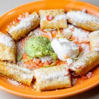 Chicken Taquitos · Crisp flour tortilla topped with fresh tasty chicken on a bed of lettuce garnished with sour...