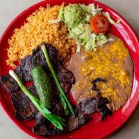 Carne Asada · Charcoal grilled sliced skirt steak served with guacamole on a bed of lettuce, tomatoes, and...