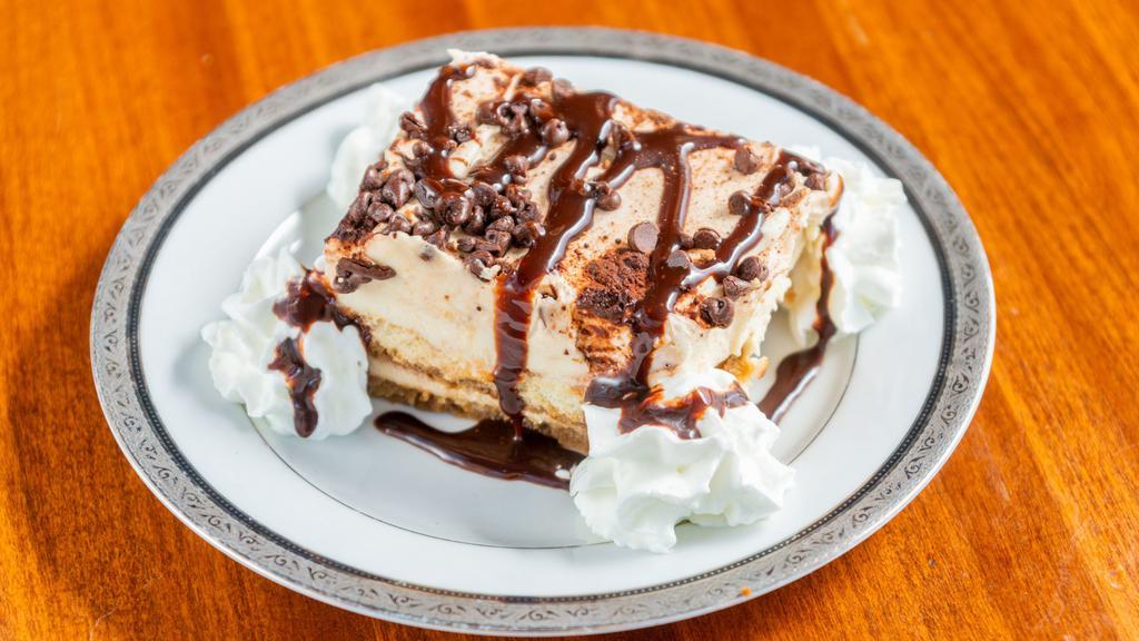 Tiramisu · Homemade traditional Italian dessert with layers of coffee and liqueur dipped lady fingers and mascarpone cheese, dusted with coco powder and chocolate drizzle