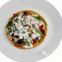 Tostada · A con crispy hard shell with beans, your choice of protein, lettuce, tomatoes, sour cream, a...