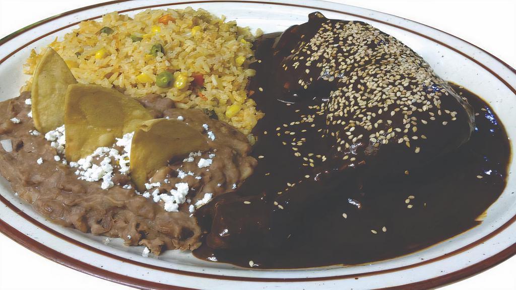 Pollo Con Mole · Diced chicken breast smothered in a rch red mole sauce that is slightly sweet and spicy, topped with sesame seeds. Served with rice & beans. This dish contains peanuts. (most mole has peanuts and or other nuts usually important to add this allergy info).