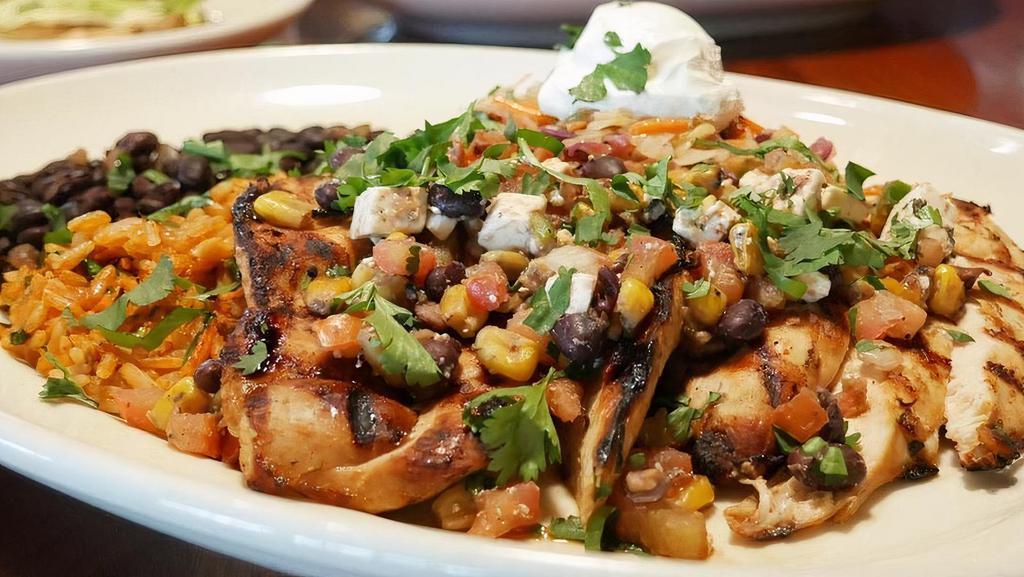 Amber Ale Chicken · Chicken breast marinated in Buttface Amber Ale, cilantro & lime juice, served with black beans, Spanish red rice, tarragon slaw, finished with. roasted corn & black bean relish, sour cream,chopped cilantro