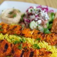 Shish Tawook Plate · Skewered marinated chicken chunks char-broiled and served over rice, comes with hummus and G...