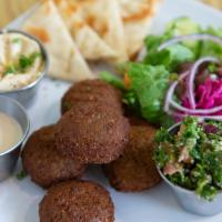 Falafel Plate · Vegan. Five pieces of falafel served with salad, hummus, topped with tahini sauce.