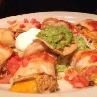 Chicken Taquitos · Crispy flour tortillas filled with chicken, rolled, and fried. Served with guacamole, sour c...