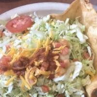 Deluxe Taco Salad · A crispy flour tortilla shell filled with whole beans, rice, your choice of beef or chicken,...