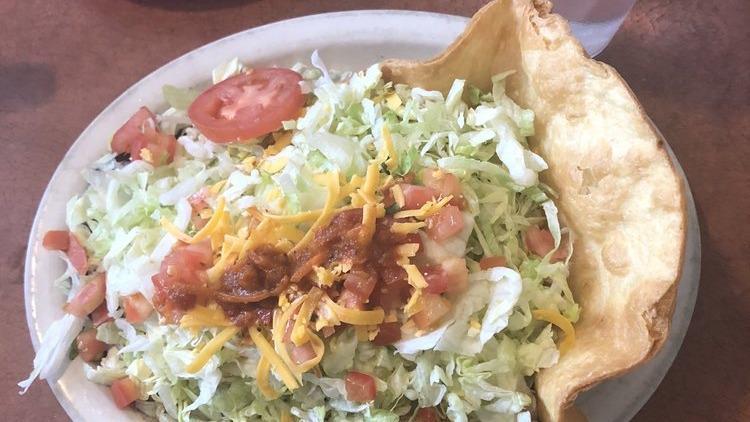 Deluxe Taco Salad · A crispy flour tortilla shell filled with whole beans, rice, your choice of beef or chicken, fresh lettuce, cheese, tomatoes, sour cream, and guacamole.