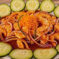 Sinaloense Tostada · Shrimp cooked in lime juice, cucumber, onion, tomato, carrot, avocado and black sauce. Toppe...