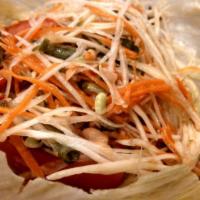 Papaya Salad · Spicy. Shredded green papaya, green beans, carrots and tomatoes tossed with tangy sauce.