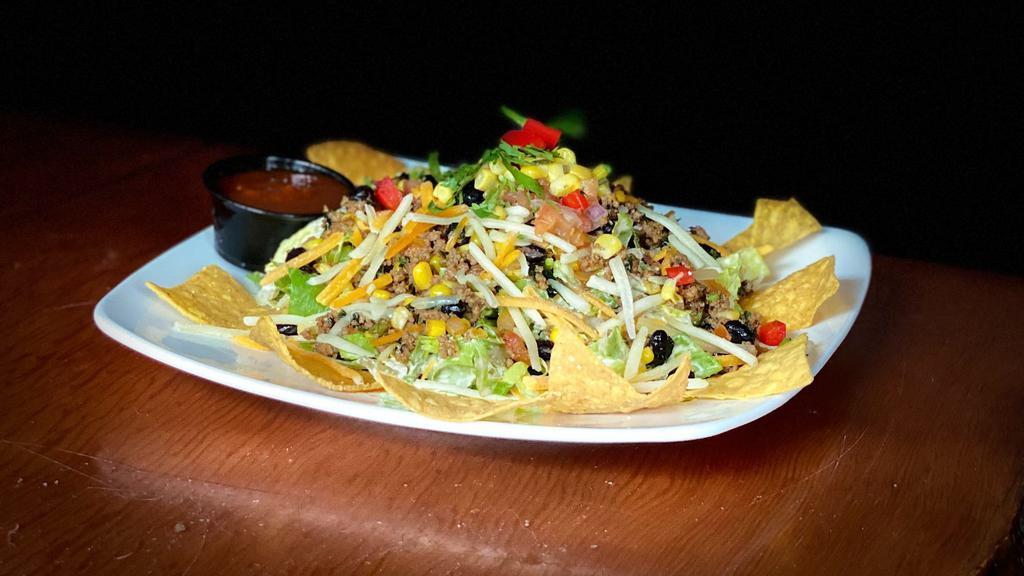 Taco Salad · Your choice of chicken or ground beef atop lettuce, fire roasted corn salsa, pepper jack and cheddar cheeses tossed in our chipotle ranch dressing. Served with tortilla chips.