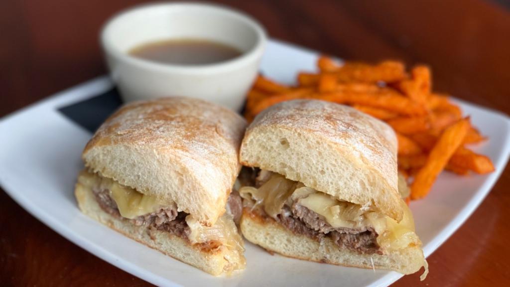 Prime Rib Dip Sandwich · Sliced prime rib with caramelized onions and swiss cheese on a toasted ciabatta bun. Served with au jus.