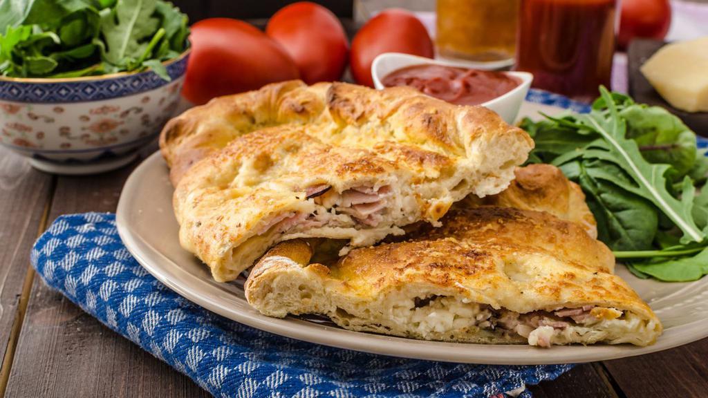 The Ham Calzone · Oven-baked calzone filled with ricotta cheese and slices of ham. Served with marinara sauce.