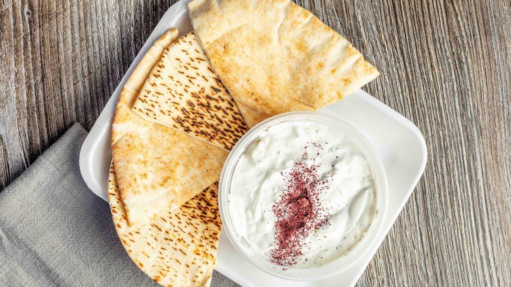 Taziki · Greek yogurt, dill, cucumber, olive oil, and a touch of mint served with pita bread.