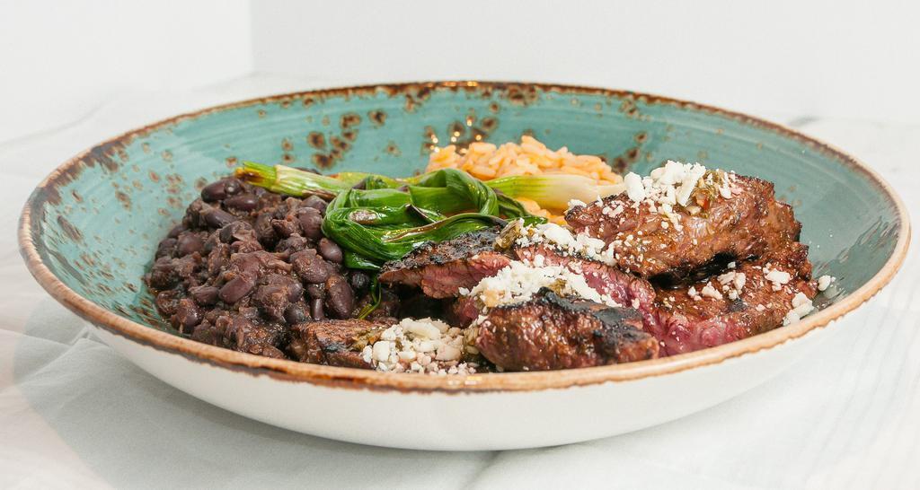 Dry Aged Skirt Steak · Gluten-free. Adobo marinated, refried beans, rice, grilled onion, chimichurri, cotija cheese.
