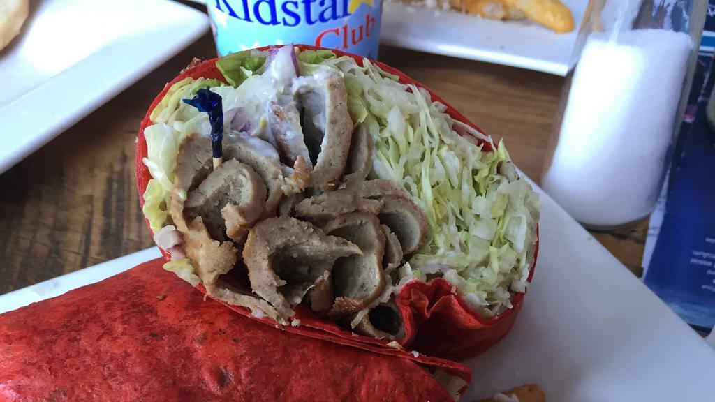 Gyro Wrap · Tomato/Basil wrap with sliced gyro meat, lettuce, roma tomatoes, onions, and tzatziki. Comes with your choice of fries or Greek salad.