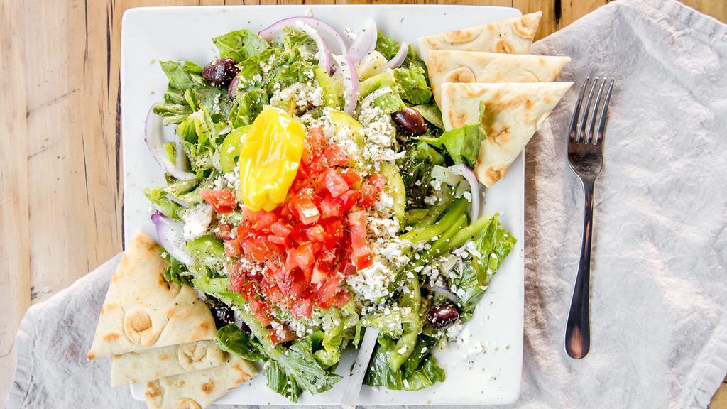 Greek Salad · Romaine lettuce, cucumbers, onions, roma tomatoes, green bell peppers, feta, kalamata olives, and house-made Greek dressing. Topped with oregano and olive oil.