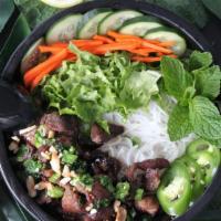 Vermicelli Bowl (Bun Thit Nuong) · Lettuce, cucumber, mint, basil, jalapenos, pickled carrots on rice noodles. Served with a li...