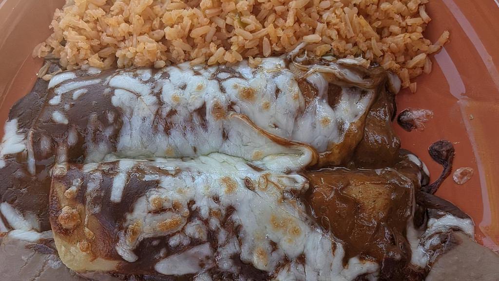 Mole Enchiladas · Two corn tortillas stuffed with your choice of meat. Topped with cheese and a sweet and spicy Mexican sauce.