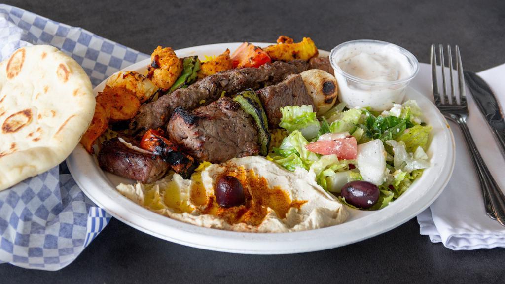 Mix Grill Plate · Three skewers of kababs, chicken, beef and Kafta served with rice, hummus, Greek salad, pita, garlic and tahini sauce.