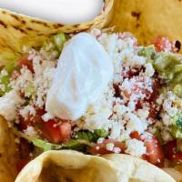 Taco Salad · Flour Tortilla , rice,lettuce, fresh cheese,sour cream, guacamole and the meat of your choice