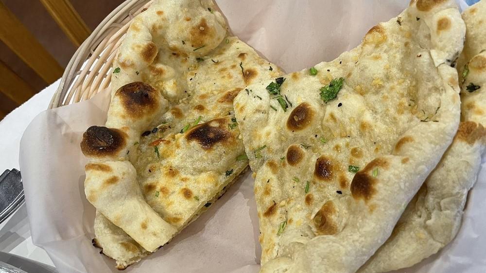 Garlic Naan · White wheat bread garnished with minced garlic and chopped cilantro.
