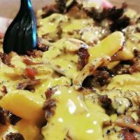 Philly Fries · Chopped ribeye steak and grilled onions on top of our thin cut crispy fries and smothered in...