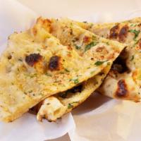 Garlic Naan · Leavened white flour bread topped with fresh garlic and coriander baked in tandoor.