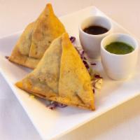 Vegetable Samosa · Served traditionally with channa masala, chopped onions and cliantro leaves smothered with s...