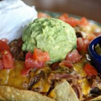 Nachos Supreme · Corn tortilla chips, shredded beef or pork, mixed cheese, sour cream, guacamole, re-fried be...