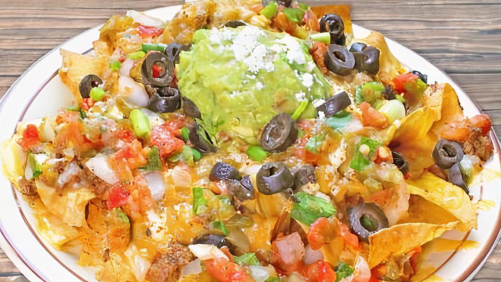 Nachos · Hot tortilla chips, melted cheese, pico de gallo, guacamole, seasoned sour cream, and sliced olives. Add machaca or shredded chicken for an additional charge.