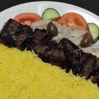 #23. Steak Plate · Marinated, tender trip-trip served with rice, seasoned onion, tomato, cucumber, pita and tza...