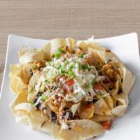 Chicken Tinga Nachos · House made corn tortilla chips covered with shredded chicken tinga, roasted vegetable stewed...