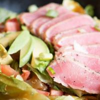Seared Ahi Salad · Seared ahi tuna atop a bed of lettuce with tomatoes, avocado and green onions.