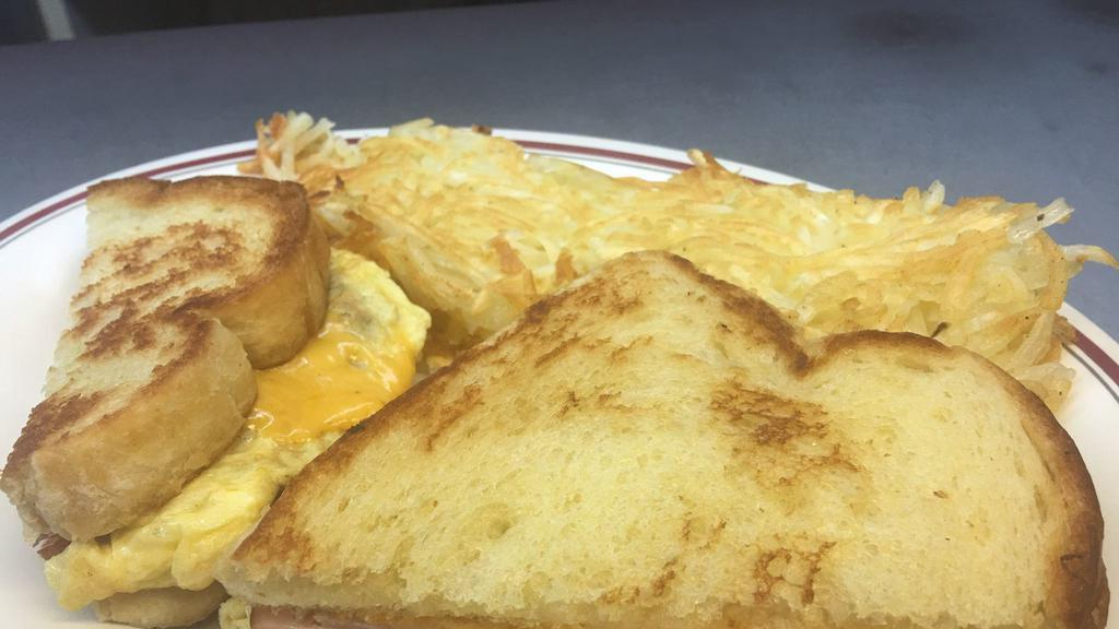 Breakfast Sandwich · Two eggs and slice of swiss or American cheese with choice of bacon sausage or ham. Served with hash browns.