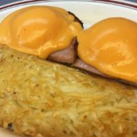 Eggs Benedict · Two eggs and ham served on an English muffin and smothered with cheese sauce. Served with ha...
