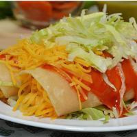 Cheese Enchiladas · Two cheese enchiladas topped with cheese and lettuce.