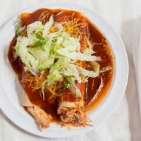 Chicken Enchiladas · Two red chicken enchiladas topped with lettuce and cheese.