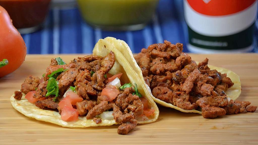 Adobada Taco · Marinated pork on a soft corn tortilla topped with guacamole and pico de gallo.